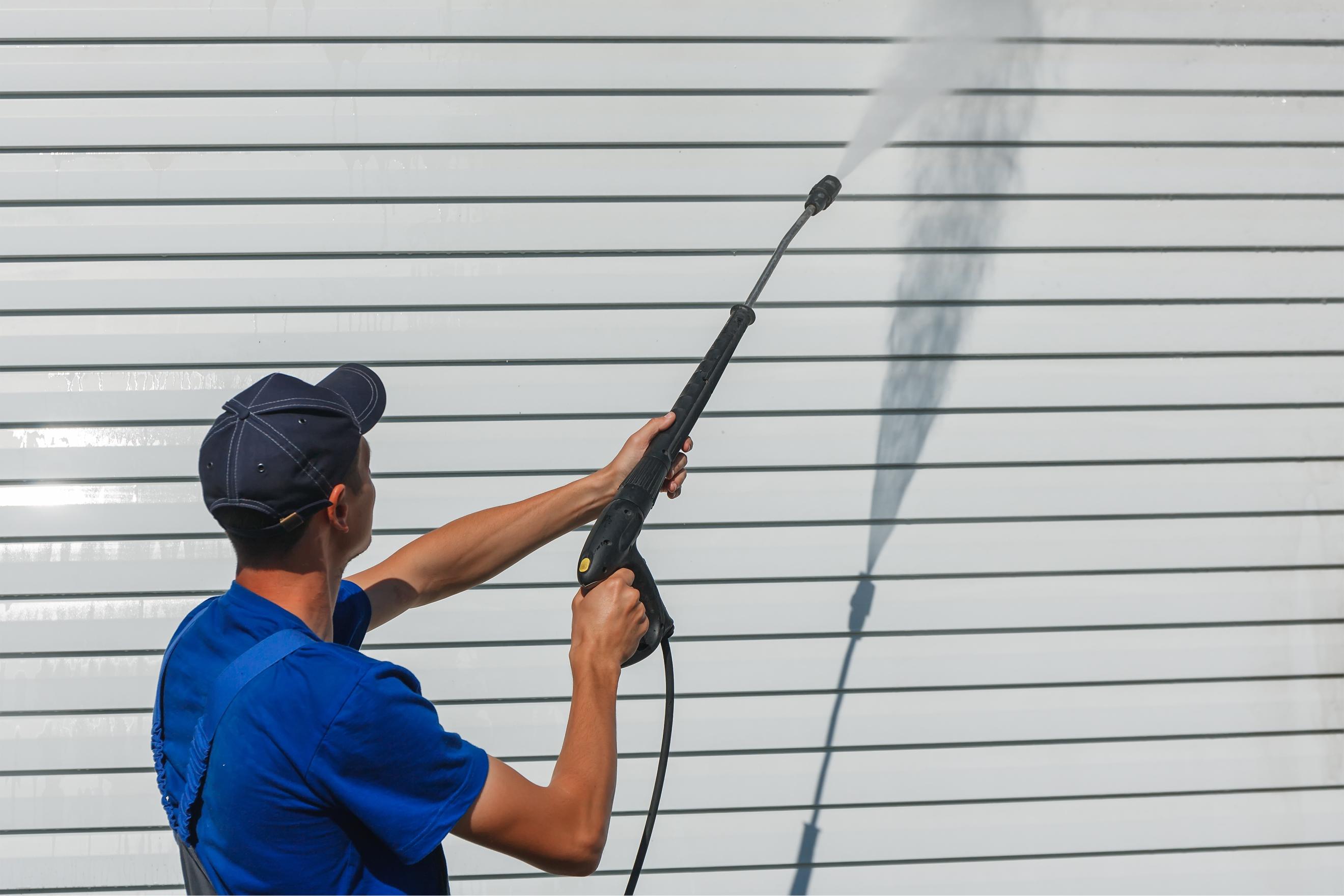 Technician performing gentle house washing on residential siding in Boulder County using soft wash technique.